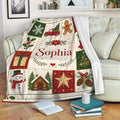 Christmas throw blanket displayed on a sofa with colorful holiday patchwork artwork and cozy living room styling
