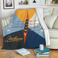 Rowing blanket draped over a sofa with colorful racing shell artwork and geometric nautical-inspired panels