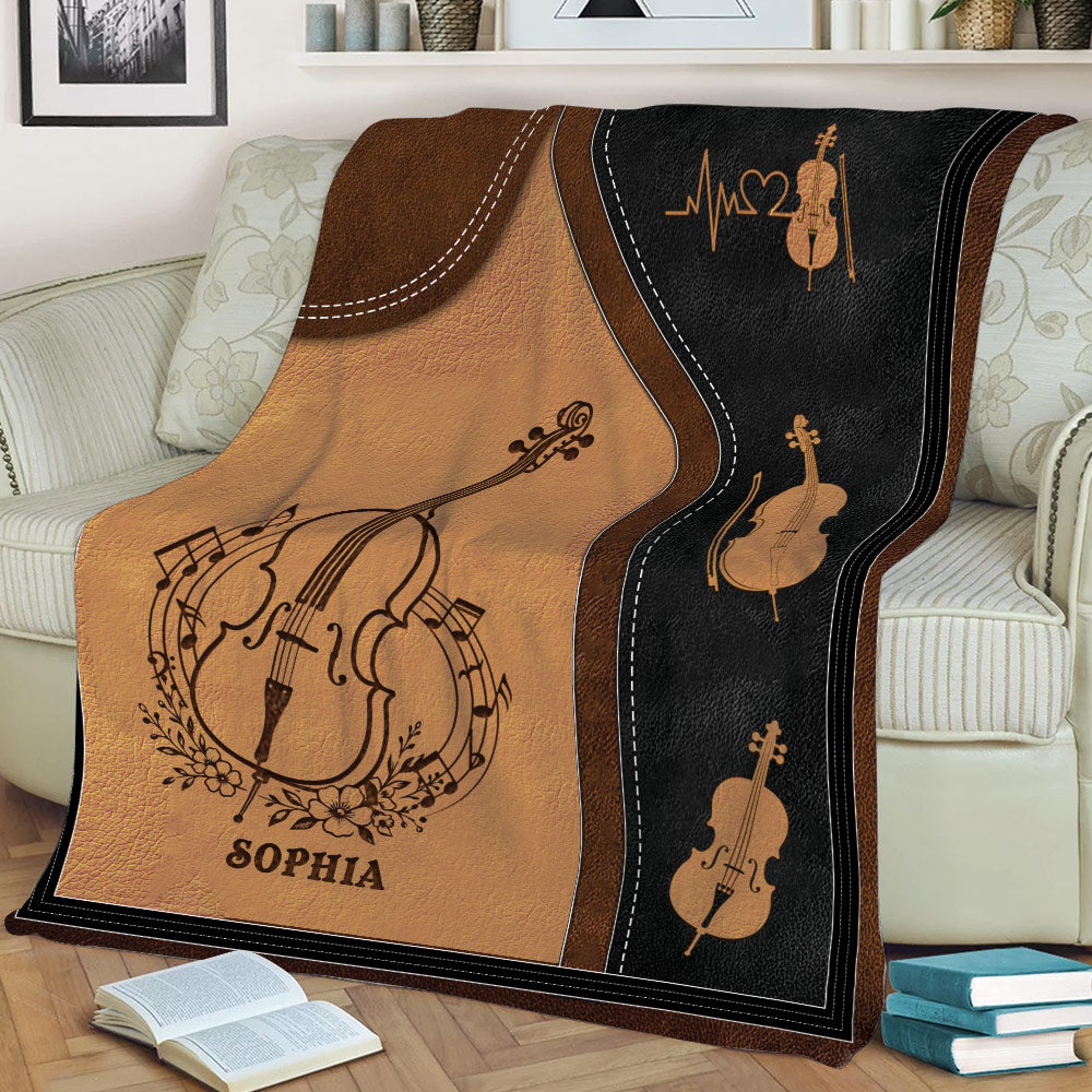 Close view of a cello blanket styled on a sofa with string instrument artwork and music-themed details