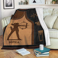 Custom archery blanket displayed on a sofa with archer, target, quiver, and warm brown and black artwork