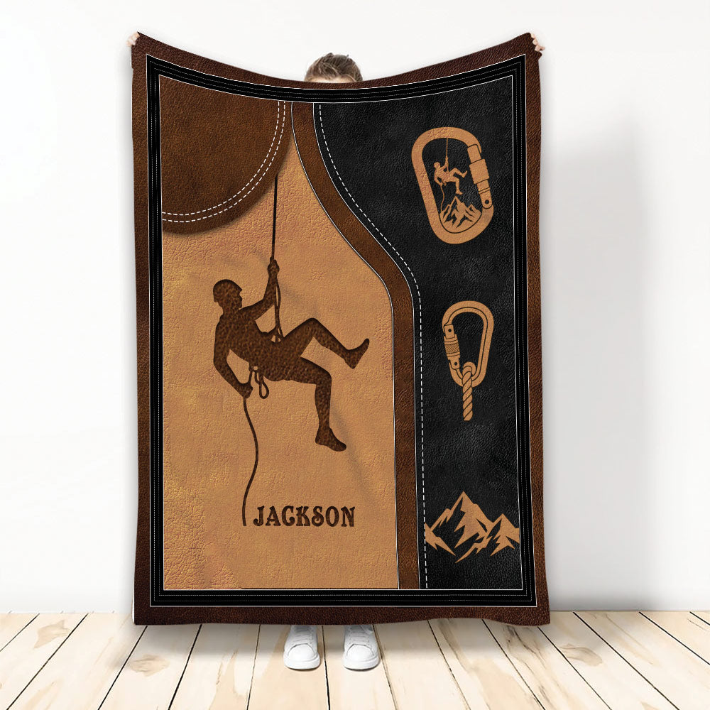 Rock climbing blanket with climber silhouette, rope, carabiners, mountains, and rustic brown and black artwork