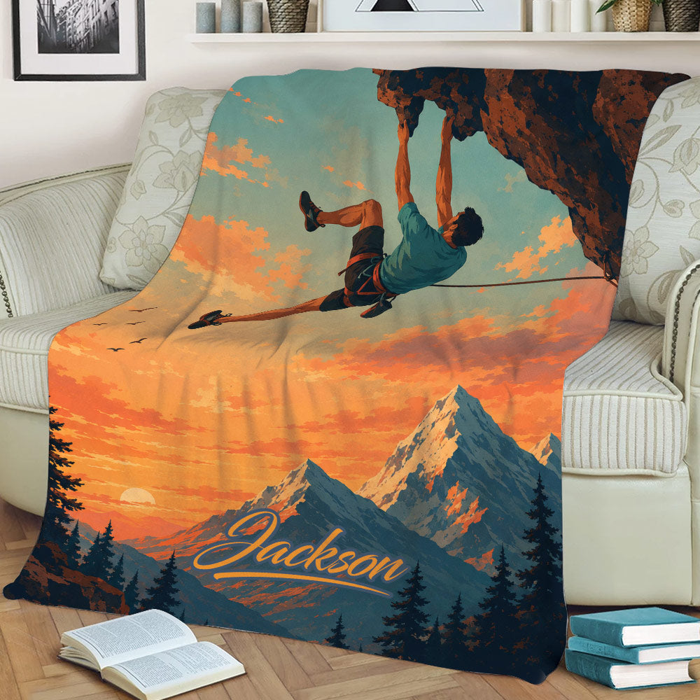 Mountain climbing blanket draped over a couch with dramatic cliff and alpine sunset artwork