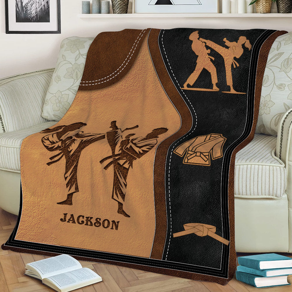 Close view of a Taekwondo blanket featuring kicking practitioners, martial arts uniforms, and belt illustrations
