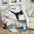 Taekwondo blanket draped over a sofa, featuring black and white martial arts artwork with red blossoms