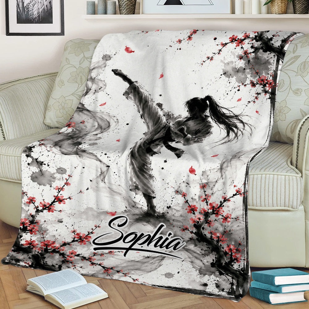 Taekwondo throw blanket displayed on a couch with dynamic martial artist and blossom design