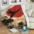 Taekwondo throw blanket displayed on a sofa with martial arts silhouette, red artwork, and scenic temple design