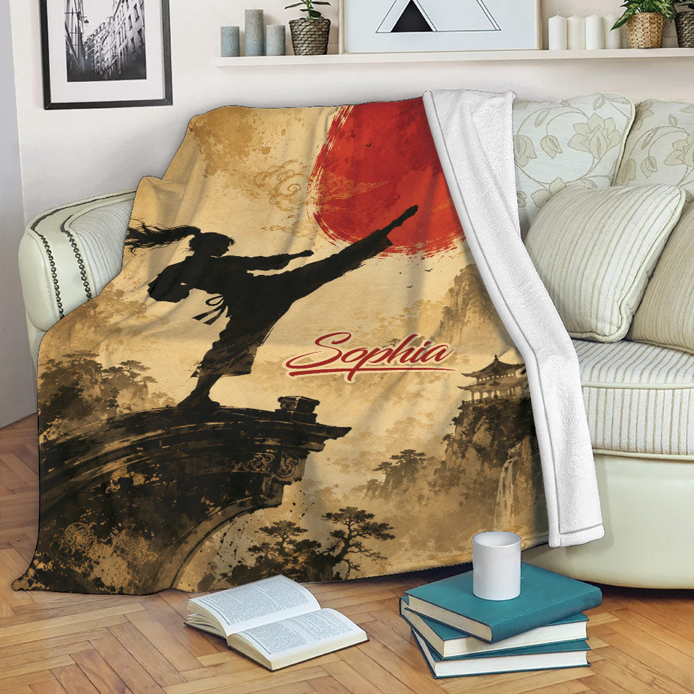 Taekwondo blanket draped over a sofa with high-kicking martial arts artwork and red sun design