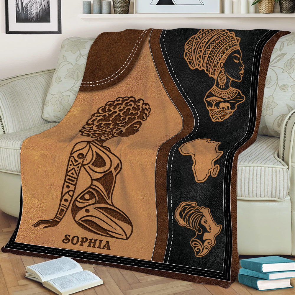 African art throw blanket displayed on a sofa with women’s silhouettes and warm geometric details