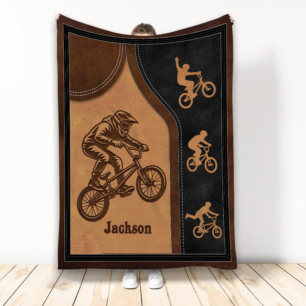BMX throw blanket with freestyle rider artwork in warm brown and black leather-look tones