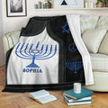 Hanukkah throw blanket draped over a sofa with blue menorah and Star of David designs