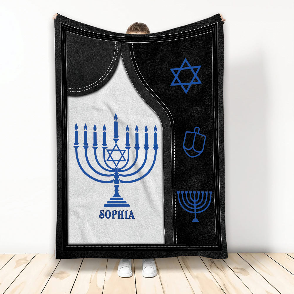 Hanukkah blanket with blue menorah, Star of David, and dreidel artwork in black and white