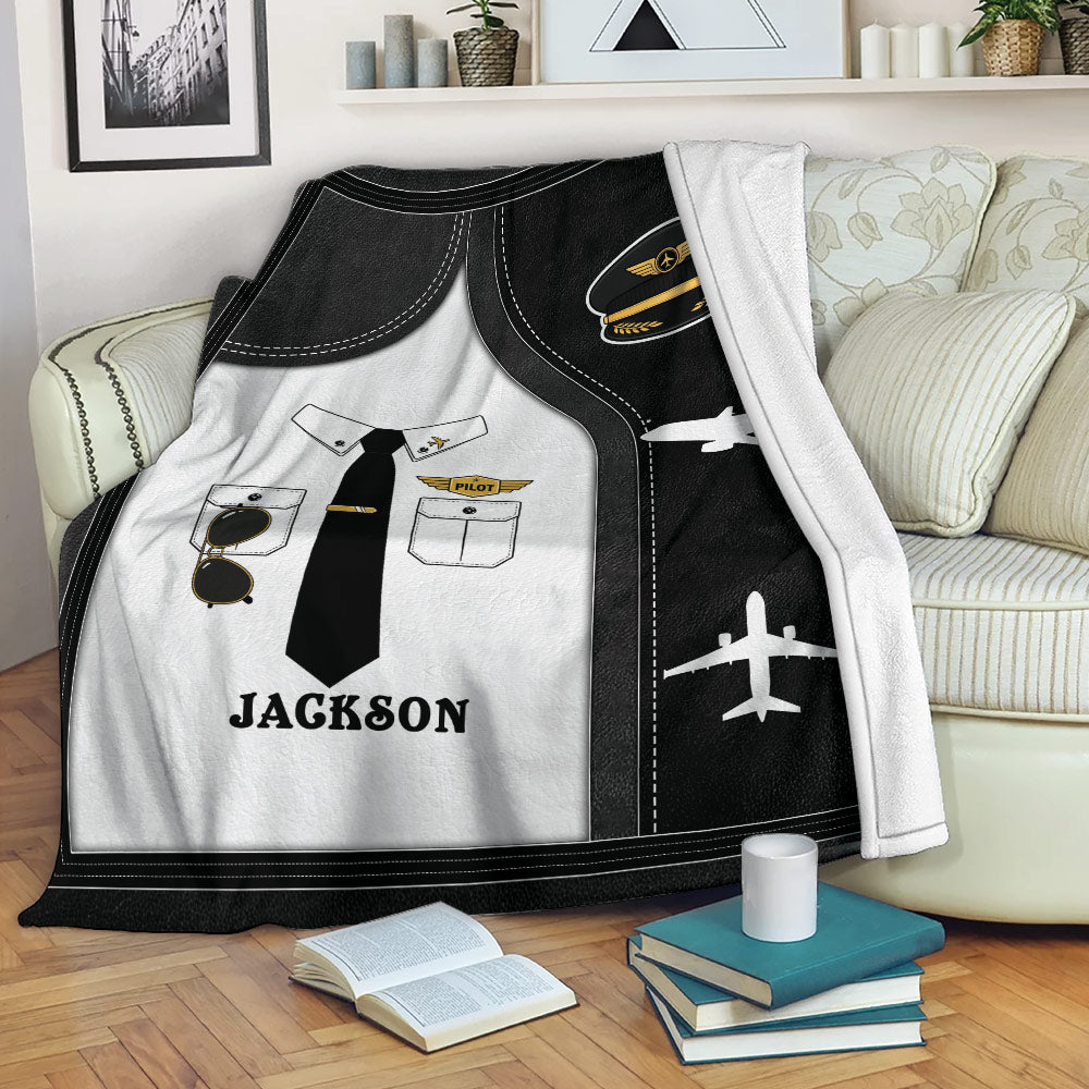 Pilot blanket displayed on a sofa with aviation uniform artwork, airplane silhouettes, and black and gold accents