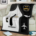 Close lifestyle view of a pilot throw blanket with captain hat artwork, uniform details, and airplane graphics
