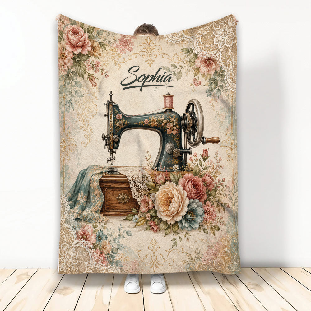 Vintage sewing machine blanket with floral fabric, lace details, thread spool, and elegant decorative artwork
