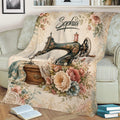 Close view of a floral sewing machine throw blanket styled on a sofa with vintage craft-inspired artwork