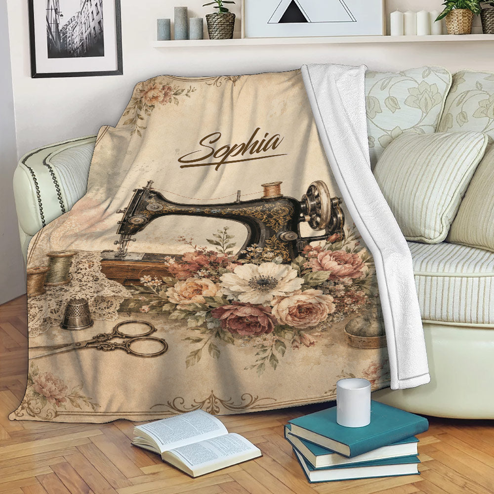 Vintage sewing throw blanket displayed on a sofa with floral sewing machine artwork and cozy reading decor