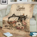 Sewing-themed throw blanket on a sofa featuring an antique sewing machine, flowers, scissors and sewing tools