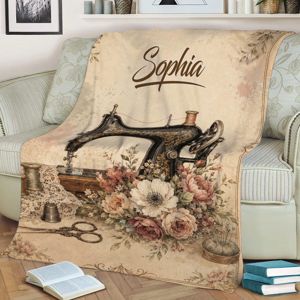 Sewing-themed throw blanket on a sofa featuring an antique sewing machine, flowers, scissors and sewing tools