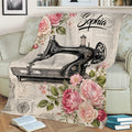 Vintage sewing machine throw blanket with floral rose artwork styled on a sofa beside books