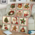 Christmas holiday blanket draped over a couch with Santa, Christmas tree, wreath and gingerbread artwork