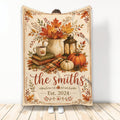 Thanksgiving blanket with autumn leaves, pumpkins, lantern, books, coffee, and rustic harvest artwork