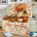Close view of a Thanksgiving sofa blanket featuring pumpkins, autumn foliage, lantern, coffee, and rustic fall details