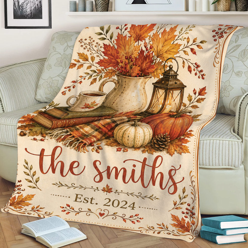 Close view of a Thanksgiving sofa blanket featuring pumpkins, autumn foliage, lantern, coffee, and rustic fall details