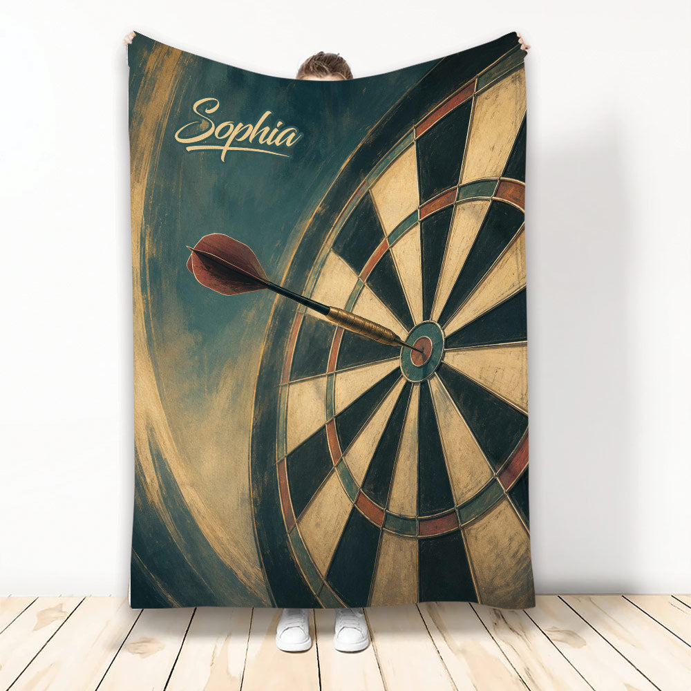Dart board throw blanket displayed upright with vintage target and dart artwork in deep teal, tan, and rust tones