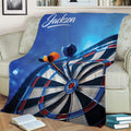 Dart board throw blanket spread across a sofa with blue, black, white, and red artwork