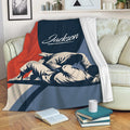 Jiu Jitsu throw blanket displayed on a sofa with bold grappling artwork and a navy, red, and blue design