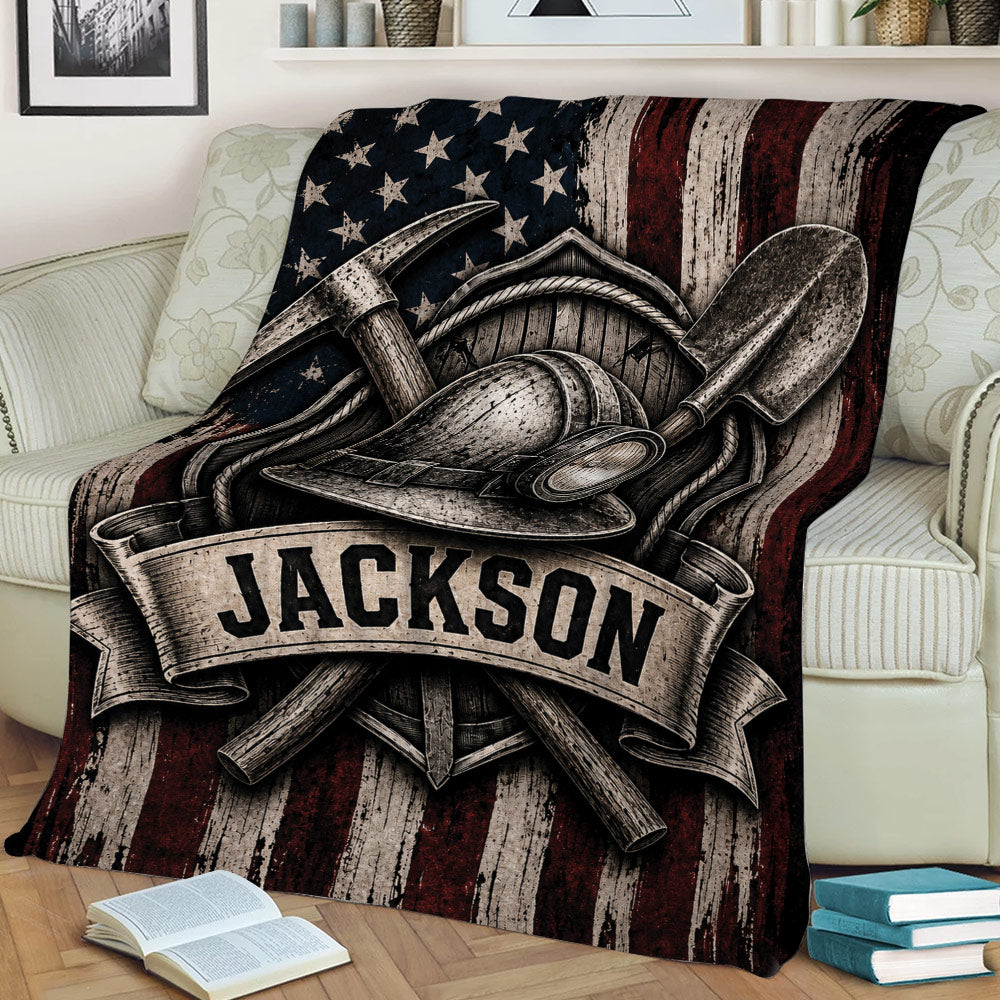 Close view of a miner throw blanket featuring a helmet, pickaxes, shovel, and rugged patriotic artwork
