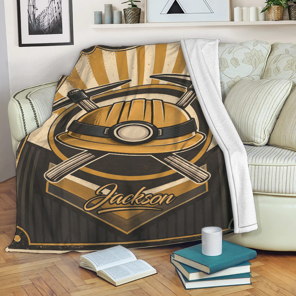 Miner throw blanket displayed on a sofa with vintage hard hat and crossed pickaxe design
