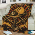 Close lifestyle view of a miner blanket featuring a hard hat, crossed pickaxes, shovel, and mountains