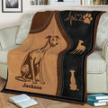 Close view of Greyhound throw blanket artwork draped across a sofa with black, brown, and tan details