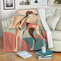 Greyhound throw blanket draped over a sofa, featuring colorful geometric artwork in a cozy living room