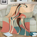 Close view of a colorful Greyhound blanket displayed on a sofa with abstract geometric shapes
