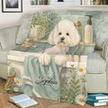 Bichon Frise blanket draped over a sofa, showing a white dog in a bathtub with greenery and daisies