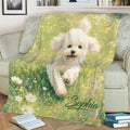 Bichon Frise blanket displayed on a sofa with a smiling white dog surrounded by meadow flowers