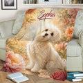 Floral Maltese throw blanket draped across a sofa, featuring a fluffy white dog and garden scenery