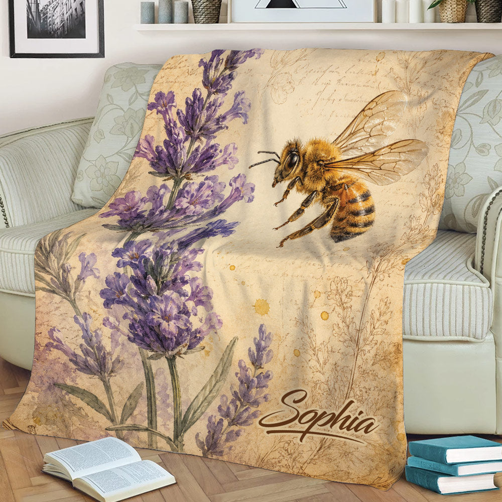 Bee blanket displayed on a sofa with lavender flowers and a vintage botanical illustration theme
