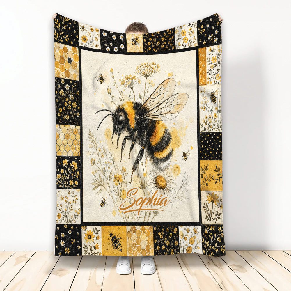 Bee throw blanket featuring a large honeybee, wildflowers, honeycomb panels, and black and golden floral borders