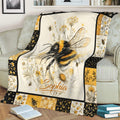 Honeybee throw blanket displayed on a sofa with botanical flowers, honeycomb details, and golden floral borders
