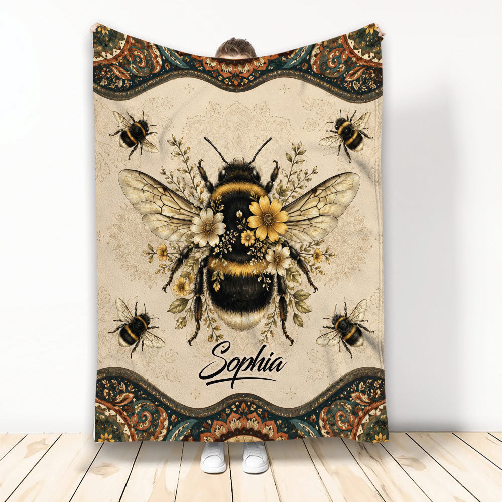 Bee blanket displayed vertically with a large floral bumblebee and ornate vintage border
