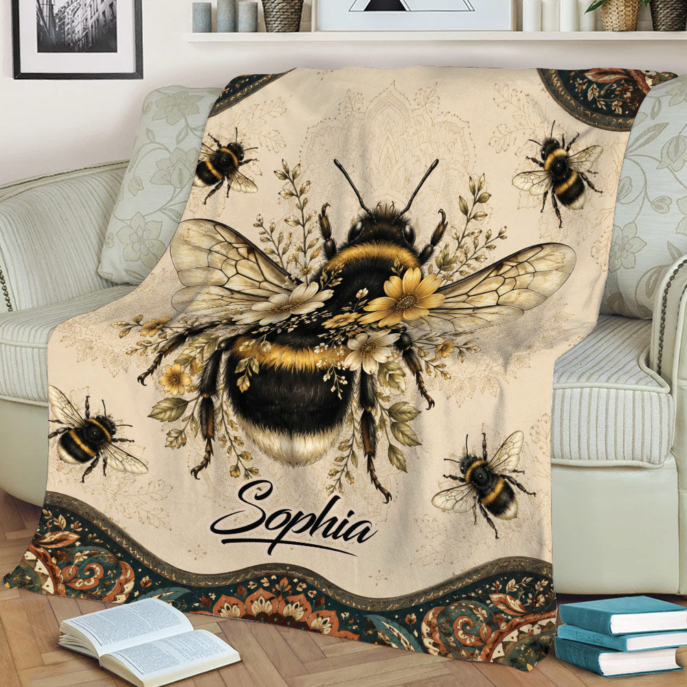 Close view of a bee throw blanket featuring a detailed bumblebee surrounded by flowers