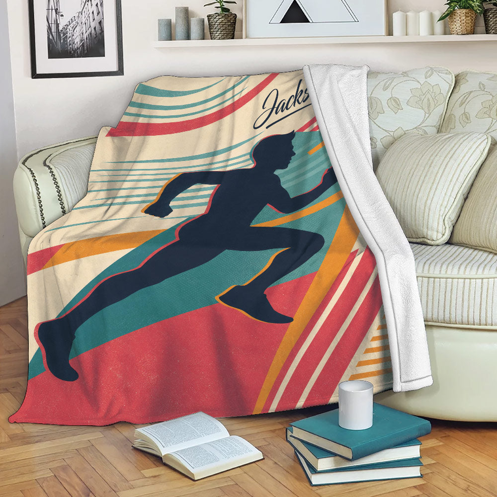 Running blanket draped over a sofa with bold runner artwork and geometric stripes