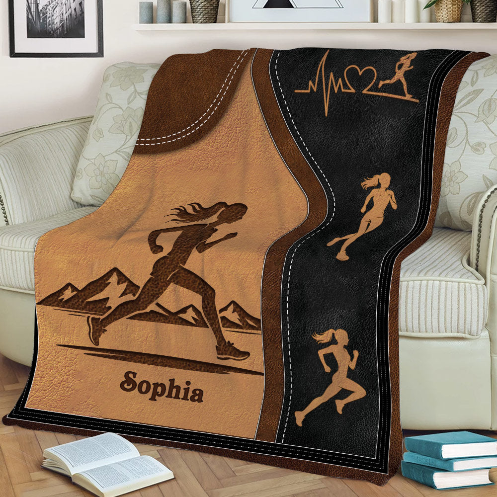 Close view of running throw blanket featuring a female runner, mountain scene, and athletic silhouettes