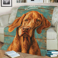 Close view of a Vizsla dog throw blanket styled over a chair with books and rustic artwork