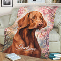 Close view of a Vizsla dog blanket featuring painterly floral branches on a living room sofa