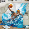Water polo throw blanket draped over a sofa, showing a player, ball, and vivid blue aquatic artwork
