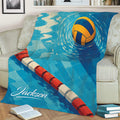 Blue water polo blanket styled on a sofa with a floating ball and red and white lane rope